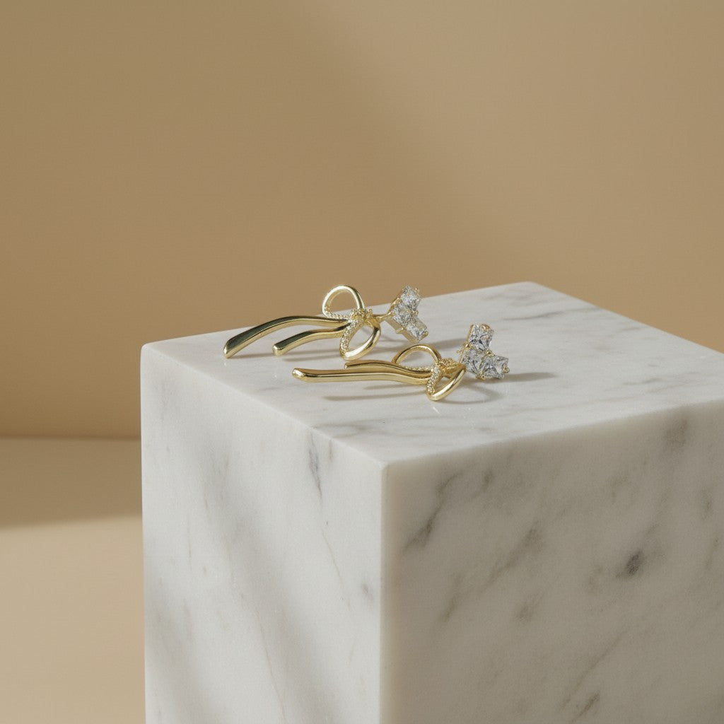 SVORA gold-tone stainless steel drop earrings with crystal-embellished bows and hearts.