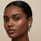 SVORA gold-tone drop earrings with crystal heart top and bow detail. Made with stainless steel and 18k gold plating.