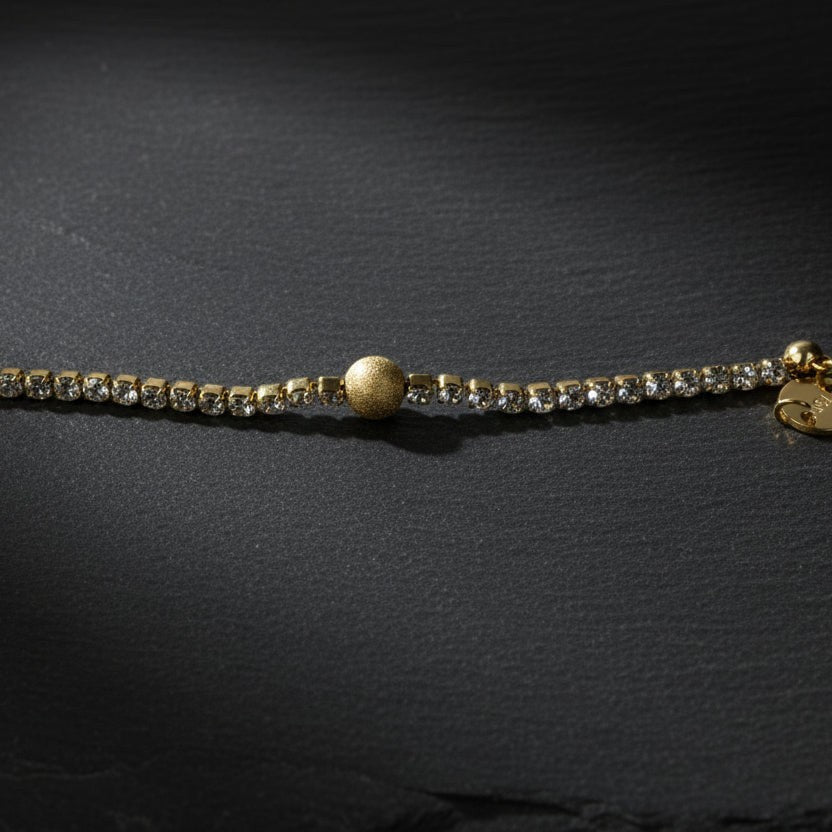 SVORA gold plated stainless steel bracelet with CZ stones and a textured gold ball accent. Adjustable.