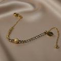 SVORA gold plated stainless steel bracelet with CZ stones and a central textured gold ball. Adjustable.