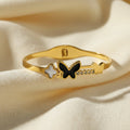 SVORA gold tone stainless steel bracelet with black onyx butterfly, white pearl clover, and small gold butterfly with cubic zirconia accents.