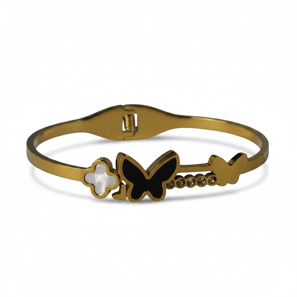 SVORA gold-plated stainless steel bracelet with black onyx butterfly, white clover, and crystal accents.