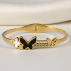 SVORA gold-plated stainless steel bracelet with black onyx butterfly, white clover, and small gold butterfly with cubic zirconia accents.