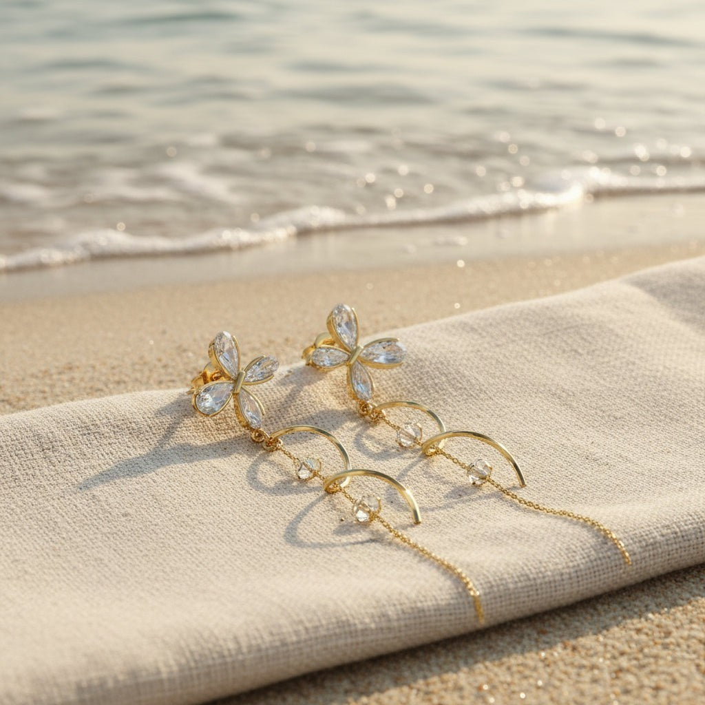 SVORA gold tone stainless steel dangle earrings with cubic zirconia butterfly tops and dual chains.