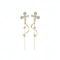 SVORA gold tone stainless steel dangle earrings with cubic zirconia butterfly tops and dual chains.