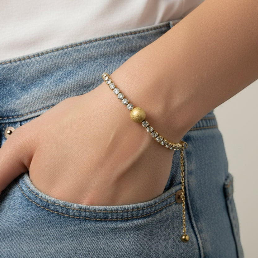 SVORA gold plated stainless steel bracelet with CZ stones and a central frosted bead. Adjustable.