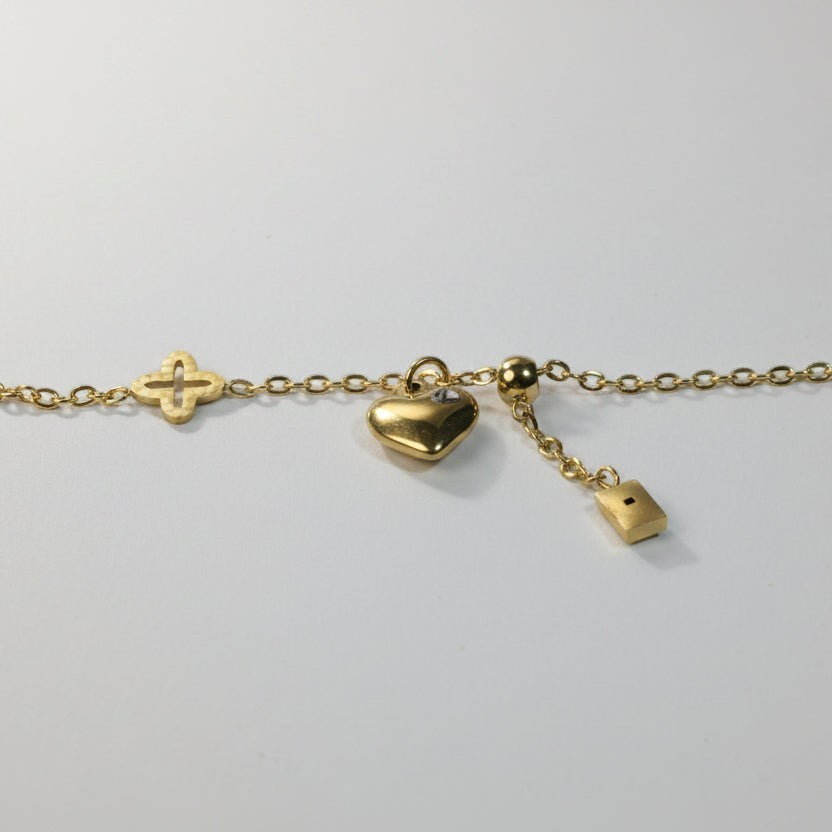 SVORA gold plated stainless steel bracelet with clover, heart, and rectangle charms. Adjustable.