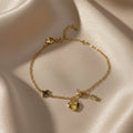 SVORA gold plated stainless steel bracelet with heart, clover, ball, and rectangle charms. Adjustable.