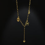 SVORA gold paperclip chain necklace with daisy, shell, coin, and heart charms. 18K gold plated stainless steel.