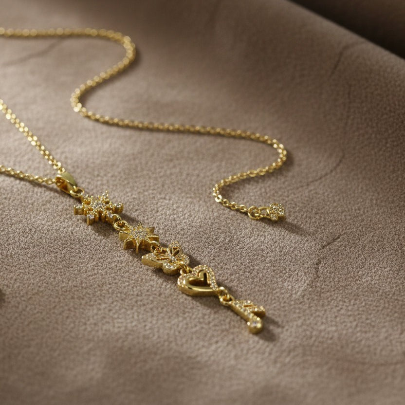 SVORA gold plated stainless steel necklace with snowflake, star, butterfly, heart, and ribbon charms.