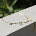 SVORA gold paperclip chain necklace with daisy, shell, coin, and heart charms. 18K gold plated stainless steel.