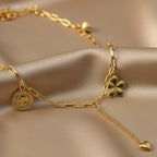 SVORA gold paperclip chain necklace with daisy, shell, coin, and heart charms. 18K gold plated stainless steel.