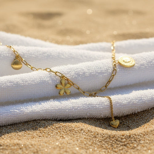 SVORA gold paperclip chain necklace with daisy, shell, coin, and heart charms. 18K gold plated stainless steel.