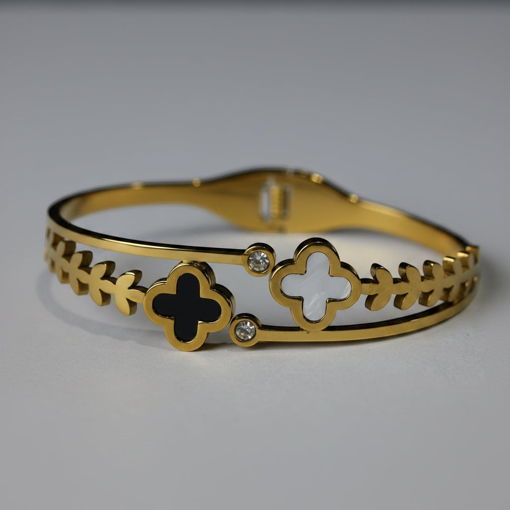 SVORA gold plated stainless steel bracelet with black onyx and mother-of-pearl clover charms and cubic zirconia accents.