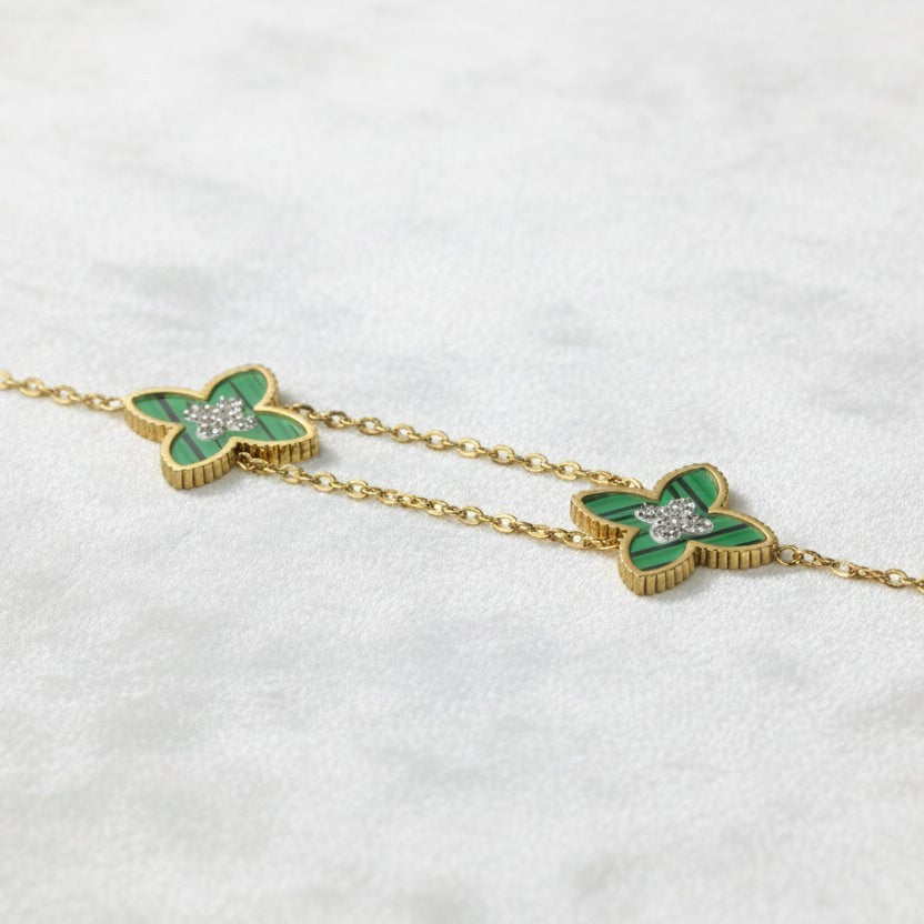 SVORA gold double-layered chain bracelet with two green clover charms, each with a diamond center.