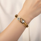 SVORA gold-plated stainless steel bracelet with black onyx and mother-of-pearl clover charms and diamond accents.