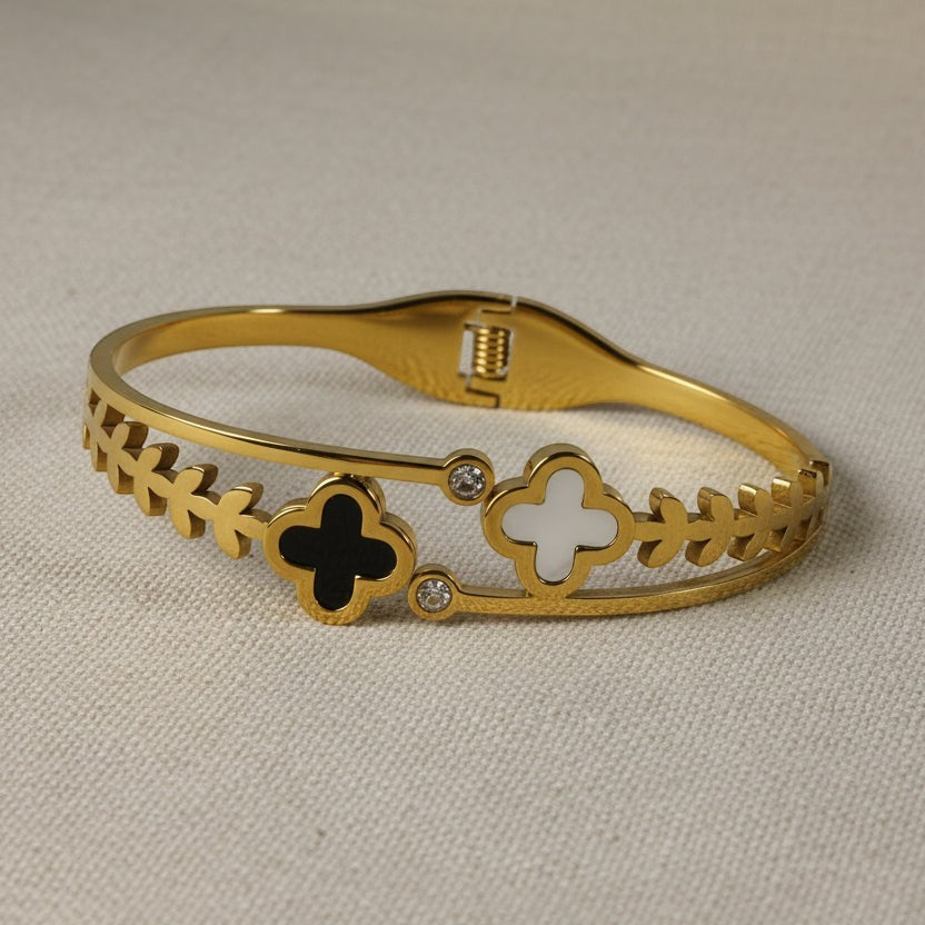 SVORA gold-plated stainless steel bracelet with black onyx and white mother-of-pearl clover charms and cubic zirconia accents.