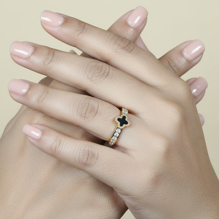 SVORA gold tone stainless steel ring with black clover motif and clear cubic zirconia accents. Waterproof, anti-tarnish, hypoallergenic.
