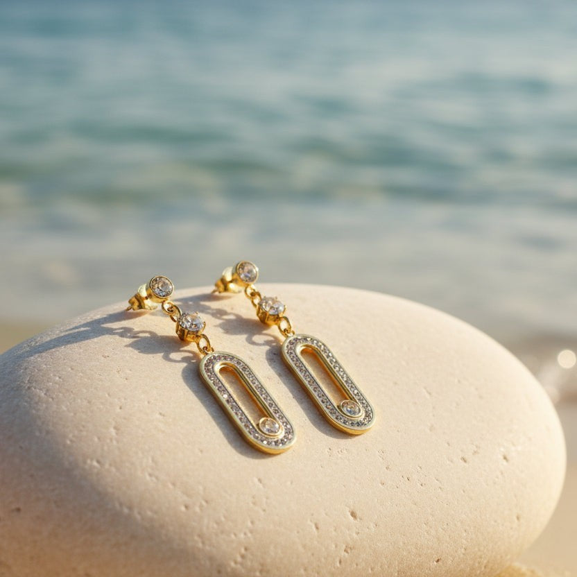 SVORA gold tone stainless steel dangle earrings with cubic zirconia connectors and oval pavé details.