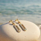 SVORA gold tone stainless steel dangle earrings with cubic zirconia connectors and oval pavé details.
