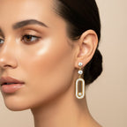 SVORA gold tone stainless steel dangle earrings with cubic zirconia, featuring a pavé connector and sliding stone detail.