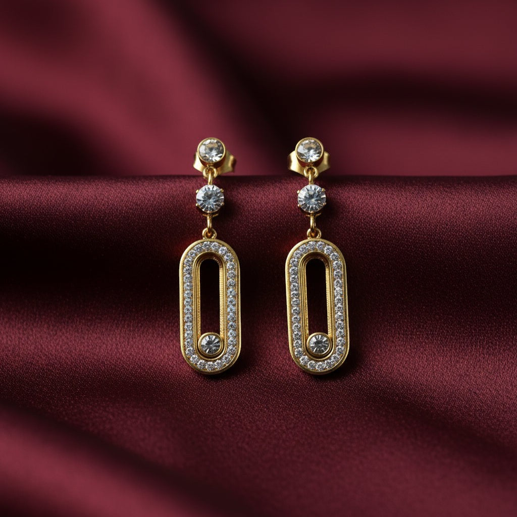 SVORA gold tone stainless steel dangle earrings with cubic zirconia and pavé connector detail.