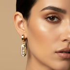 SVORA gold tone stainless steel dangler earrings with cubic zirconia stones and high polish finish.