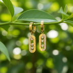 SVORA gold tone stainless steel dangler earrings with cubic zirconia stones and pavé bar detail.