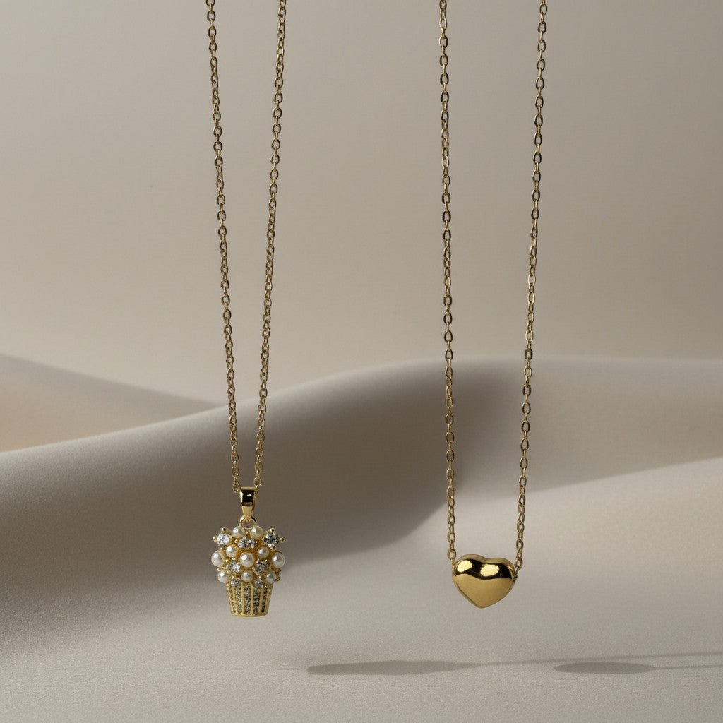SVORA gold tone stainless steel necklace with a cupcake-shaped pendant adorned with pearls and crystals.