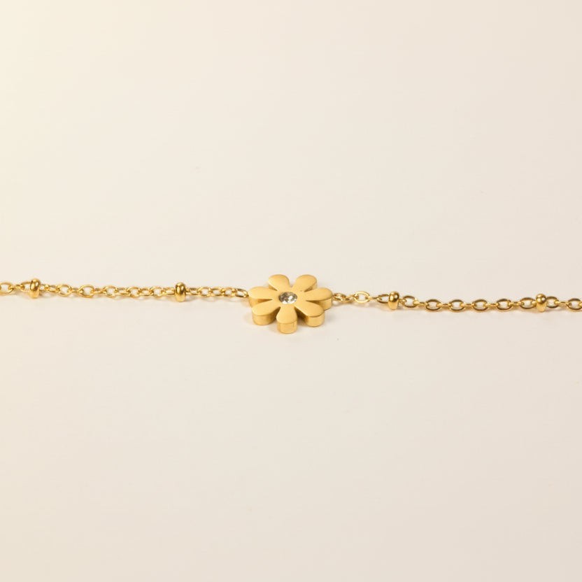 SVORA gold-plated stainless steel daisy chain bracelet with a clear cubic zirconia stone. Adjustable lobster clasp.