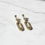 SVORA gold tone stainless steel dangle earrings with cubic zirconia and pavé connector detail.