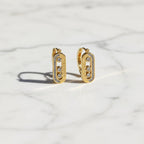 SVORA gold tone stainless steel dangler earrings with three cubic zirconia stones and pavé accents.