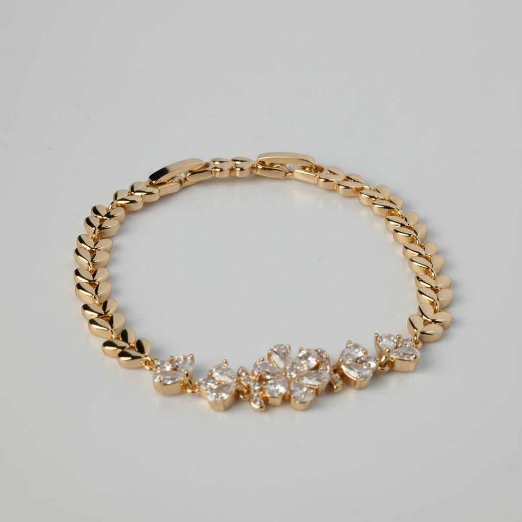 SVORA gold chain bracelet with CZ flowers and leaf links. Adjustable fold-over clasp.