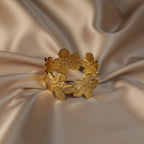 SVORA gold cuff bracelet with five sculpted floral blooms, diamond-cut finish, 18K gold plated stainless steel.