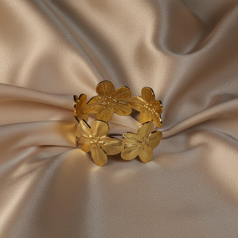 SVORA gold cuff bracelet with five sculpted floral blooms, diamond-cut finish, 18K gold plated stainless steel.