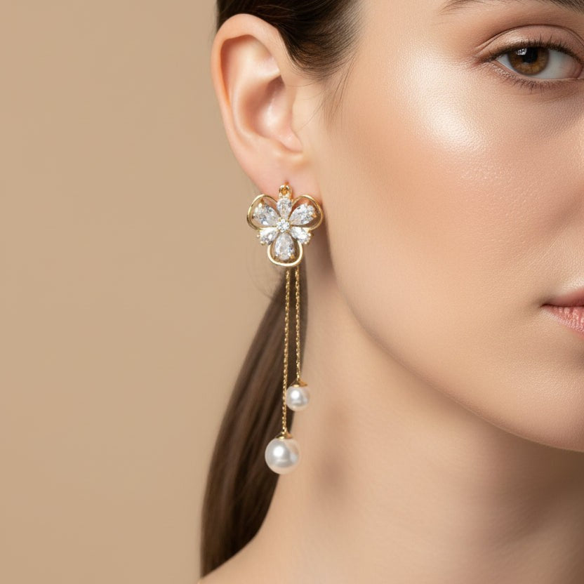 SVORA gold tone dangle earrings with cubic zirconia flower stud and pearl drops on fine chains.