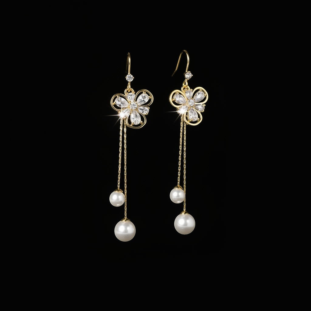 SVORA gold tone dangle earrings with cubic zirconia flower studs and pearl drops on chains.