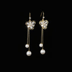 SVORA gold tone dangle earrings with cubic zirconia flower studs and pearl drops on chains.