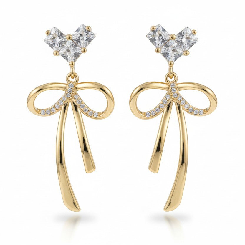 SVORA gold-tone stainless steel dangle earrings with cubic zirconia heart tops and bow drops.