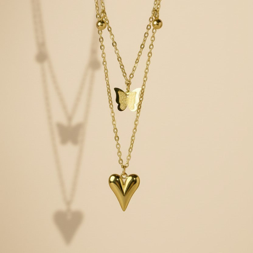 SVORA gold puffy heart and butterfly charm layered necklace made of stainless steel with 18k gold plating.
