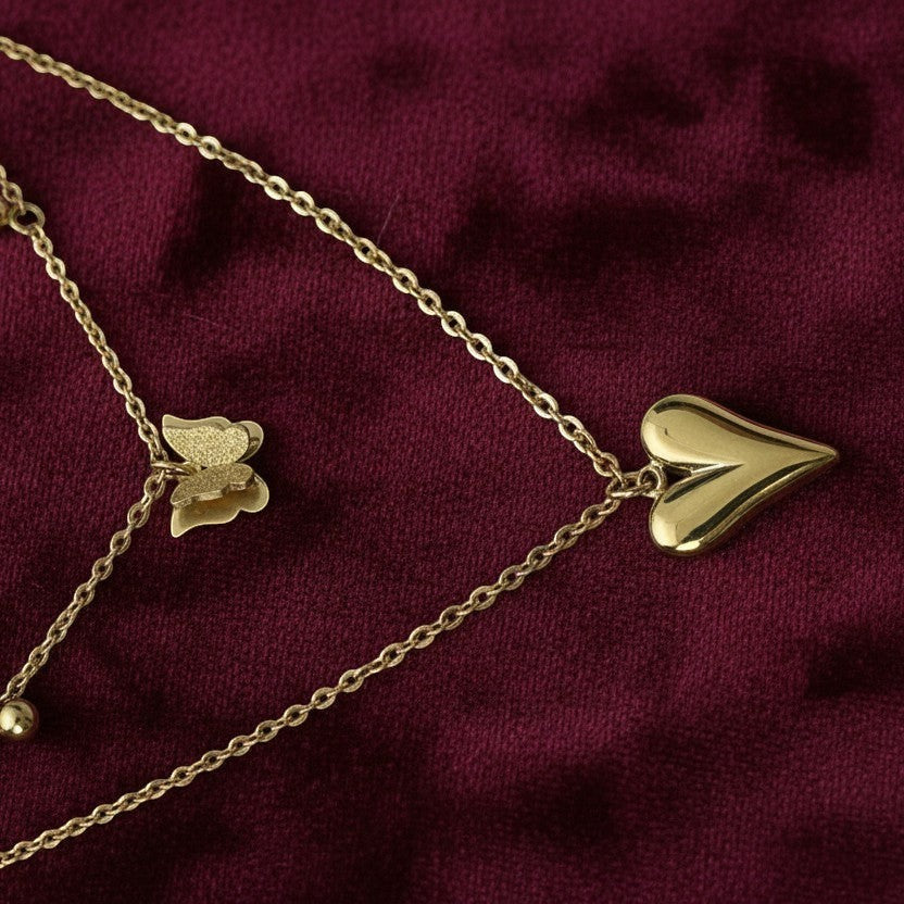 SVORA gold puffy heart and butterfly charm layered necklace made of stainless steel with 18k gold plating.