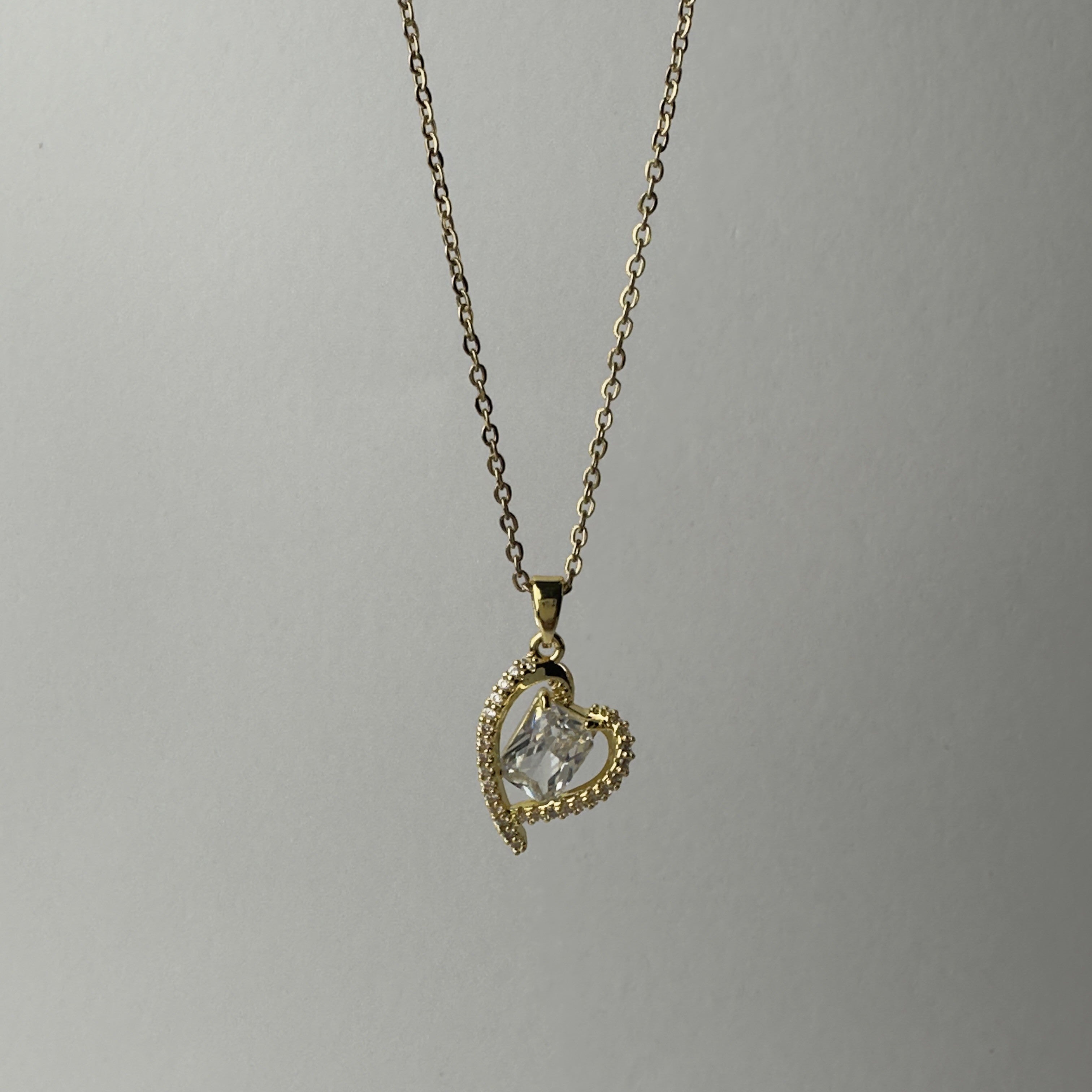 SVORA gold-plated stainless steel necklace with a heart-shaped pendant encrusted with small crystals and a central clear crystal.
