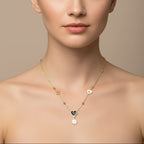 SVORA gold-tone stainless steel necklace with black enamel heart and daisy charms, featuring hollow heart cutouts.