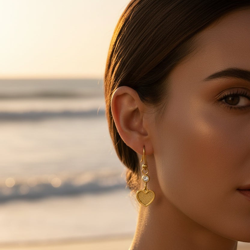SVORA gold tone stainless steel dangle earrings with cubic zirconia and textured heart charm.