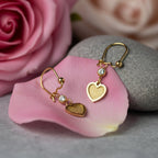 SVORA gold tone stainless steel dangle earrings with cubic zirconia and textured heart charms.