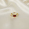 SVORA gold-tone stainless steel ring with a red heart-shaped cubic zirconia and cutout heart details.