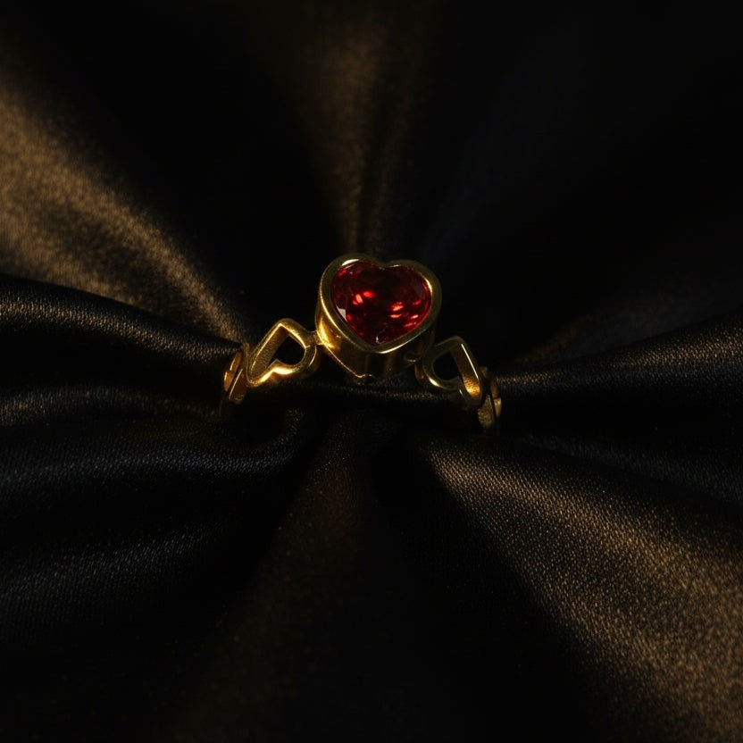 SVORA gold-plated stainless steel ring with a red heart-shaped cubic zirconia and heart details on the band.