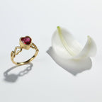 SVORA gold-plated stainless steel ring with a ruby red heart-shaped cubic zirconia and heart cutouts on the band.