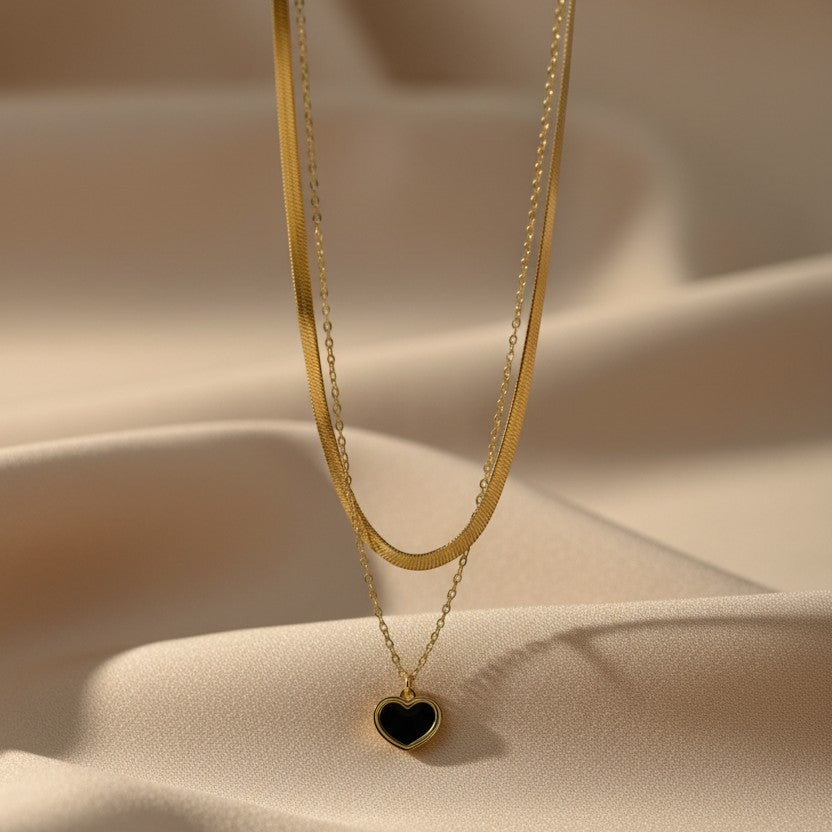 SVORA gold layered necklace with snake chain and black enamel heart pendant. Stainless steel, 18k gold plating.