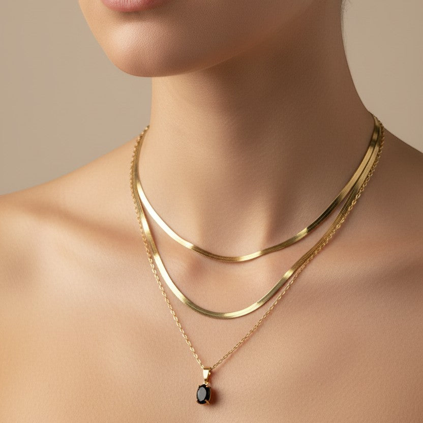 SVORA layered gold necklace with a black onyx oval pendant and snake chain, 18k gold plated stainless steel.